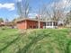 The backyard includes a screened-in porch, a well-kept lawn, and a brick house with classic charm at 9406 Northeastern Ave, Indianapolis, IN 46239