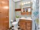 Bathroom with wood vanity, classic black and white flooring, and floral curtain at 9406 Northeastern Ave, Indianapolis, IN 46239