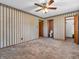A room featuring multiple doors with a ceiling fan and striped wallpaper at 9406 Northeastern Ave, Indianapolis, IN 46239