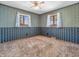 Empty bedroom with floral wallpaper, two windows, and neutral carpet at 9406 Northeastern Ave, Indianapolis, IN 46239