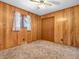 A vintage bedroom with wood paneling, a ceiling fan, and double door closet at 9406 Northeastern Ave, Indianapolis, IN 46239