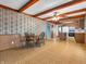 Open dining and kitchen area features a wood-paneled wall and access to kitchen appliances at 9406 Northeastern Ave, Indianapolis, IN 46239