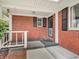 The front porch features classic brickwork and a secure black iron security door at 9406 Northeastern Ave, Indianapolis, IN 46239