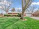 Beautiful brick ranch-style home features a lush green lawn and mature trees in the front yard at 9406 Northeastern Ave, Indianapolis, IN 46239