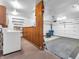 Organized garage with washer, shelving, wood paneling and garage door at 9406 Northeastern Ave, Indianapolis, IN 46239