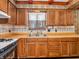 Bright kitchen featuring wooden cabinets, a double basin sink, and updated backsplash at 9406 Northeastern Ave, Indianapolis, IN 46239