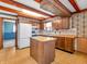 Charming kitchen features wood cabinets, island, and access to other rooms at 9406 Northeastern Ave, Indianapolis, IN 46239