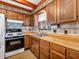 Bright kitchen featuring wooden cabinets, a double basin sink, and updated backsplash at 9406 Northeastern Ave, Indianapolis, IN 46239