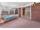 A sunroom featuring a brick wall and a futon with a view at 9406 Northeastern Ave, Indianapolis, IN 46239