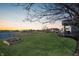 Spacious backyard with a manicured lawn and a serene view of the pond with wrought iron fence at 1043 Palomar Dr, Westfield, IN 46074