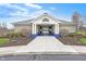 Entrance to community clubhouse with stone facade, blue accents, a paved walkway, and manicured landscaping at 1043 Palomar Dr, Westfield, IN 46074