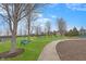 Community playground with swings, benches, and climbing structure, set in a grassy area with mature trees at 1043 Palomar Dr, Westfield, IN 46074