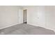 Neutral bedroom with gray carpet, white trim, and two doors, offering a blank canvas for personalization at 10522 Hunters Crossing Blvd, Indianapolis, IN 46239