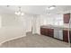 Open kitchen with stainless steel appliances, wood cabinets, and seamless flow to the dining area at 10522 Hunters Crossing Blvd, Indianapolis, IN 46239
