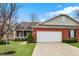 Charming brick home with attached two-car garage, green lawn, and lovely landscaping at 10629 Medinah Dr # 1, Indianapolis, IN 46234