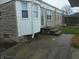 Back entrance to the house with stone and siding exterior and a well maintained and landscaped yard at 1106 N Hartman Dr, Indianapolis, IN 46219