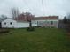 Scenic backyard with a picnic table, manicured lawn, mature trees, and views of the house and garage at 1106 N Hartman Dr, Indianapolis, IN 46219