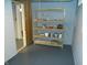 Basement storage area with shelving unit, painted floor and block walls at 1106 N Hartman Dr, Indianapolis, IN 46219
