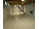 Open basement area, including stairs to upper level, tile floors and painted walls at 1106 N Hartman Dr, Indianapolis, IN 46219