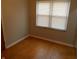 Bedroom features hardwood floors and a large window with blinds at 1106 N Hartman Dr, Indianapolis, IN 46219