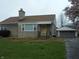 Well-maintained home with stone exterior, detached garage, and a neatly kept front lawn at 1106 N Hartman Dr, Indianapolis, IN 46219