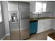 Bright kitchen area boasts stainless refrigerator and updated backsplash at 1106 N Hartman Dr, Indianapolis, IN 46219