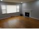 Bright living room boasts hardwood floors, fireplace, and multiple windows at 1106 N Hartman Dr, Indianapolis, IN 46219