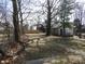 Spacious backyard with a fence, trees, and a mix of grass and leaves at 1153 W 29Th St, Indianapolis, IN 46208