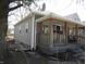 Charming home with a welcoming front porch, gray siding, and mature trees at 1153 W 29Th St, Indianapolis, IN 46208