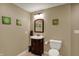 Powder room with vanity, wood mirror frame, decorative succulent wall art and tan ceramic tile flooring at 11629 Boothbay Ln, Fishers, IN 46037