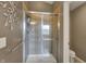 Bathroom with a glass-enclosed shower, gray tiled walls, and a mounted towel rack at 11629 Boothbay Ln, Fishers, IN 46037