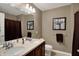 Well-lit bathroom featuring double sinks, a vanity, and decorative wall art at 11629 Boothbay Ln, Fishers, IN 46037
