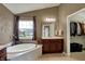 Bathroom featuring a large tub, vanity, and a doorway to a walk-in closet at 11629 Boothbay Ln, Fishers, IN 46037