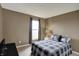 Bedroom features a bed with a gray plaid comforter, a window, and a lamp at 11629 Boothbay Ln, Fishers, IN 46037