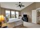 Spacious bedroom with large windows, a ceiling fan, a sitting chair and an entertainment center at 11629 Boothbay Ln, Fishers, IN 46037