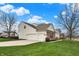 Back exterior of home featuring a three-car garage, vinyl siding, and well-manicured lawn at 11629 Boothbay Ln, Fishers, IN 46037