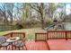 Wooden deck features backyard with mature trees, playset and grass at 12198 Blue Springs Ln, Fishers, IN 46037