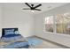 Bright bedroom with carpet, a ceiling fan, and a view of the trees at 12198 Blue Springs Ln, Fishers, IN 46037