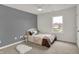 Cozy bedroom with gray accent wall, plush carpet, and large window overlooking the neighborhood at 12198 Blue Springs Ln, Fishers, IN 46037