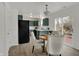 Bright dining area with deck access adjacent to the kitchen featuring modern appliances and green cabinets at 12198 Blue Springs Ln, Fishers, IN 46037
