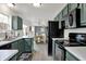 Modern kitchen featuring sleek appliances, green cabinets, and an adjacent dining area with seating at 12198 Blue Springs Ln, Fishers, IN 46037