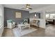 Comfortable living room with stylish decor, including plush seating, a ceiling fan, and elegant artwork at 12198 Blue Springs Ln, Fishers, IN 46037