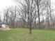 The large, lush backyard features mature trees with an open lawn area, and a wooden deck at 12441 Bent Oak Ln, Indianapolis, IN 46236