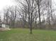 Large grassy backyard with a wooden deck and a backdrop of trees at 12441 Bent Oak Ln, Indianapolis, IN 46236