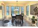 Dining area with large windows offering natural light, dark wood table with chairs, and decorative plants at 12441 Bent Oak Ln, Indianapolis, IN 46236