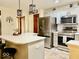 Bright kitchen features white cabinets, stainless steel appliances, island with bar seating, and stylish pendant lighting at 12441 Bent Oak Ln, Indianapolis, IN 46236
