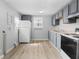 Well-lit kitchen with wood countertops, a refrigerator, and gray cabinetry at 1313 W Memorial Dr, Muncie, IN 47302