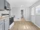 Functional kitchen with gray cabinets, laminate flooring, and access to additional rooms at 1313 W Memorial Dr, Muncie, IN 47302