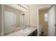 Bright bathroom features a large mirror, sink, and an open doorway to an adjacent toilet and shower at 1436 Amberwoods Ct, Indianapolis, IN 46239