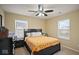 A cozy bedroom with a black bed frame and a bright, patterned comforter with a ceiling fan at 1436 Amberwoods Ct, Indianapolis, IN 46239